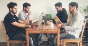 Vier klonen van elkaar zitten aan dezelfde tafel te werken als collega's.